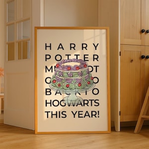 May include: A framed print with the text "HARRY POTTER... BACK TO HOGWARTS THIS YEAR!" features a layered cake illustration. The cake has purple, green, and red accents, and sits on a white pedestal. The frame is a light brown color.