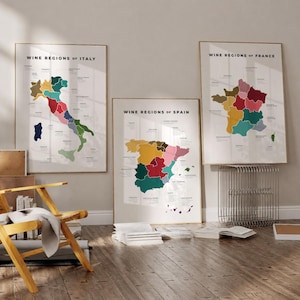 May include: Three framed posters showing colourful maps of wine regions. The posters are labelled "Wine Regions of Italy", "Wine Regions of Spain", and "Wine Regions of France". The maps are in gold frames and are displayed on a neutral wall.