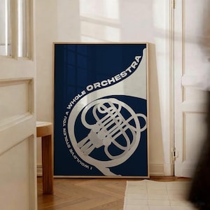 May include: A framed art print with a silver French horn design on a navy blue background. The text "I WOULD'VE STOLEN YOU A WHOLE ORCHESTRA" is printed around the horn. The artwork is displayed in a room with a wooden floor and a white door.