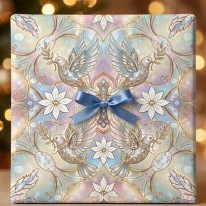 May include: A square gift box wrapped in paper featuring a symmetrical pattern of white doves holding olive branches and white flowers against a pastel blue, pink, and gold background, centered with a small, tied blue satin ribbon bow.