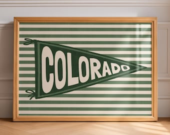 May include: A framed horizontal print featuring a dark green and white striped background. Centered on the print is a dark green triangular pennant with the word COLORADO written in large, bold, white capital letters across its surface.
