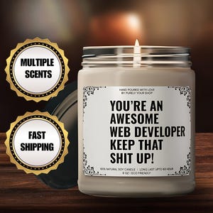 Könnte beinhalten: Eine braune Sojawachskerze mit einem weißen Etikett, auf dem "You're an Awesome Web Developer Keep That Shit Up!" steht. Die Kerze ist 9 oz groß und umweltfreundlich. Das Etikett gibt auch an, dass die Kerze zu 100% aus natürlichem Sojawachs besteht und bis zu 60 Stunden brennt.