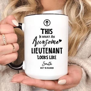 May include: White ceramic mug with a black handle and rim. The mug features the text "THIS Is WHAT AN Awesome LIEUTENANT LOOKS LIKE" in black script. Below the text is the name "Smith" and the date "EST 10.10.2025".