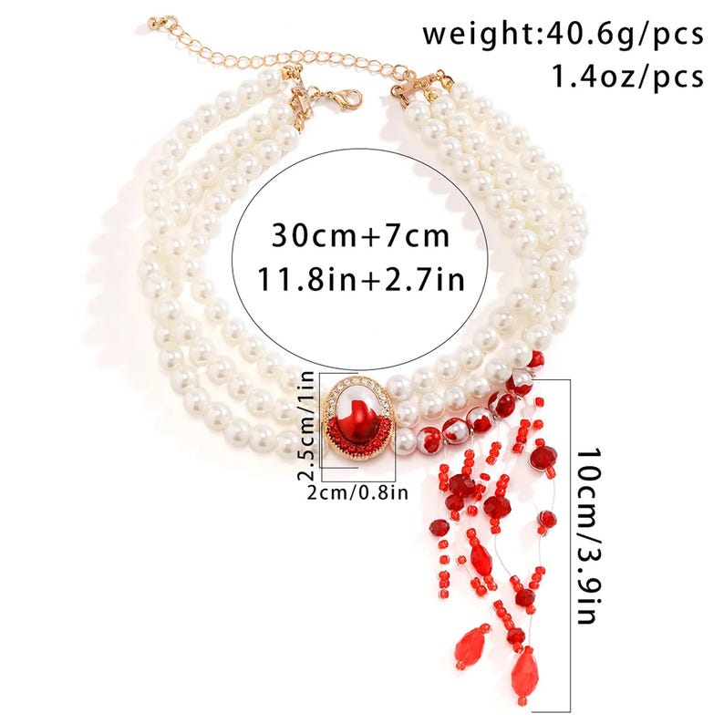 May include: A white pearl necklace with a red and gold pendant. The necklace is 30 inches long with a 7-inch extender. The pendant is 2 inches in diameter and has a red stone in the center. The necklace is 1.4 ounces.