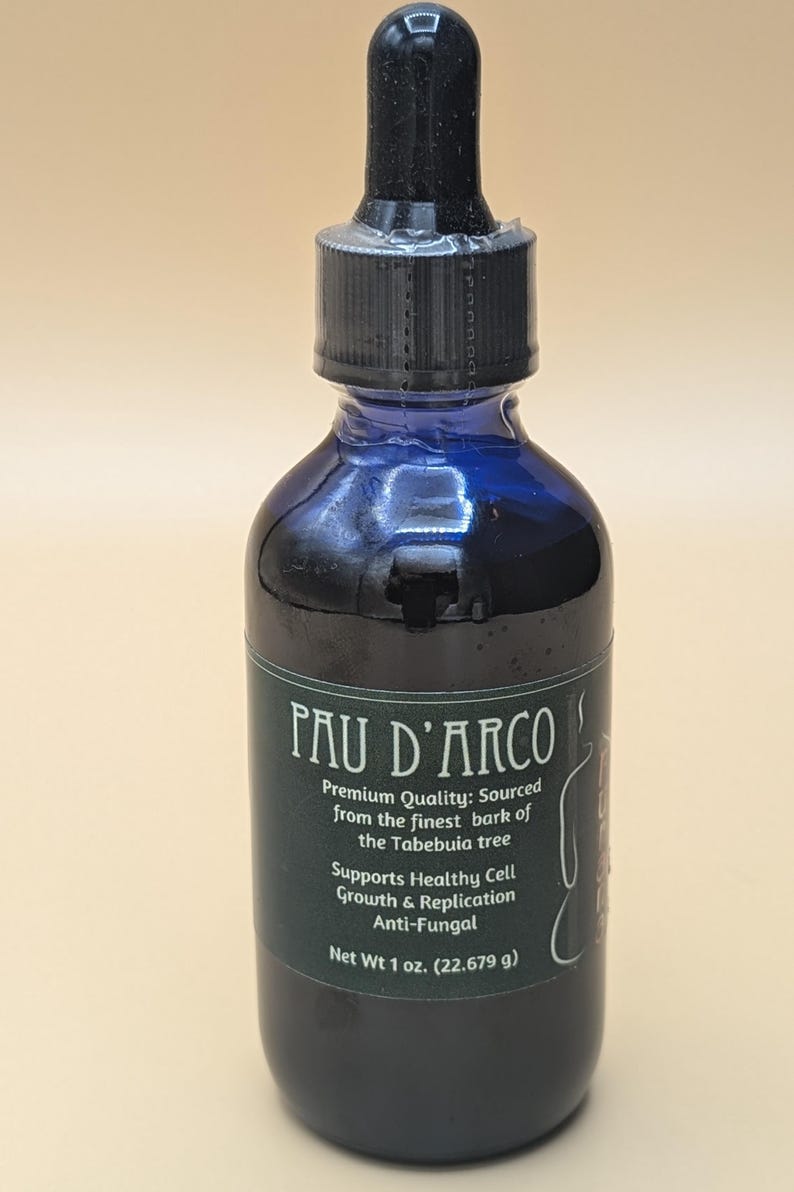 May include: A dark blue glass bottle with a black dropper top. The bottle is labeled "Pau D'Arco" and contains a dark liquid. The label also states "Premium Quality: Sourced from the finest bark of the Tabebuia tree" and "Supports Healthy Cell Growth & Replication Anti-Fungal". The bottle contains 1 ounce (22.679 grams) of liquid.