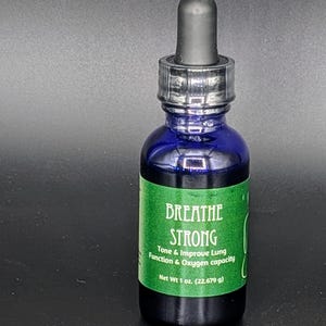 May include: A blue glass bottle with a dropper top and a green label that reads "BREATHE STRONG Tone & Improve Lung Function & Oxygen capacity Net Wt 1 oz. (22.679 g)"