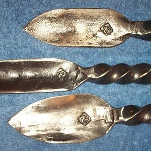May include: Three hand-forged metal tools with twisted handles. Each tool has a different shaped blade and is marked with the letter "K" in a diamond shape.