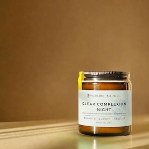 Puede incluir: Un pequeño frasco de vidrio ámbar con tapa de rosca negra y una etiqueta blanca que dice Highland Tallow Co. Clear Complexion Night, Night Deep Repair Care For Breakout Prone Skin, Balance, Clarify, Restore, Net Wt 4 oz (113 g).