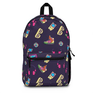 Könnte beinhalten: Ein dunkelvioletter Rucksack mit einem sich wiederholenden Muster aus Retro-Grafiken der 80er und 90er Jahre. Das Muster umfasst Turnschuhe, Kopfhörer, Sonnenbrillen, Handheld-Konsolen und Rubik's Würfel in leuchtenden Farben. Der Rucksack hat einen schwarzen Reißverschluss und einen schwarzen Tragegriff.