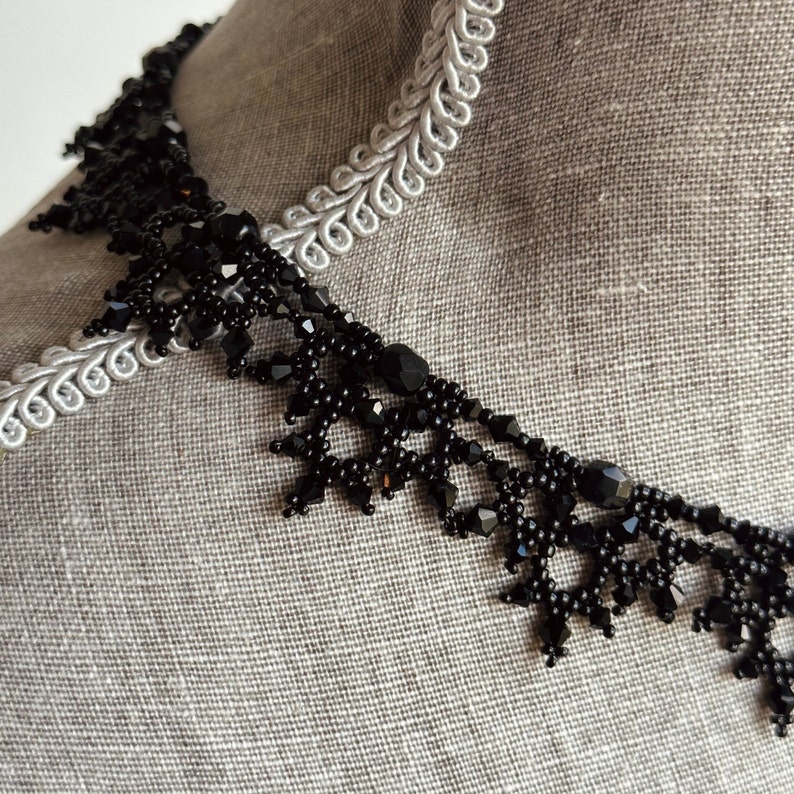 Close up of an elaborate handmade beaded necklace by Isabel Design Studio, in shiny black.