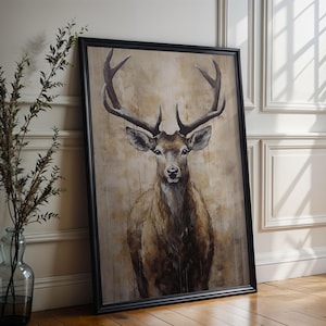 May include: A framed painting of a brown deer with large antlers standing in a forest setting. The deer is looking directly at the viewer. The background is a muted brown and beige color.