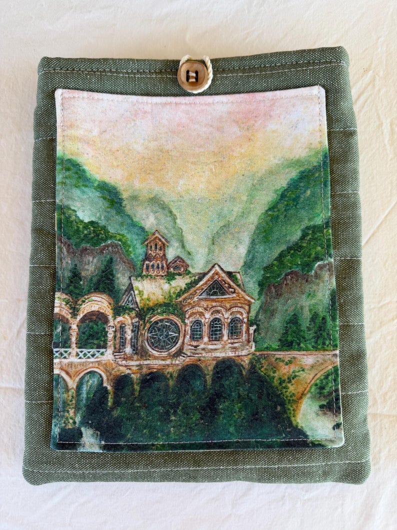 Op de afbeelding: Groene stoffen boekomslag met een aquarel schilderij van een gebouw in een berglandschap. De omslag heeft een knoopsluiting. De schildering toont een gebouw met boogvensters en een brug.