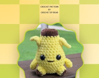 Può includere: Un peluche all'uncinetto giallo e marrone a forma di banana sbucciata con occhi in plastica nera e una piccola bocca ricamata. Il testo PEEL LEE SPRITE CROCHET PATTERN BY CROCHET BY BEAR è visualizzato sopra il peluche su sfondo a scacchi.