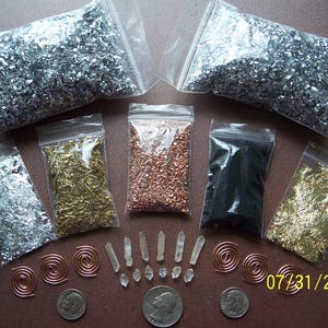 May include: Assortment of small bags containing various metallic flakes, including silver, gold, copper, and black. There are also clear quartz crystals, copper wire coils, and coins.