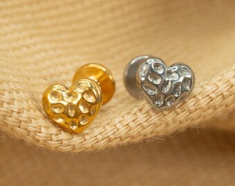May include: Two heart-shaped earrings with a textured surface. One earring is gold and the other is silver.