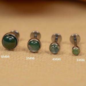 Puede incluir: Cuatro tachuelas de joyer&iacute;a corporal plateadas con piedras de &aacute;gata verde. Las piedras tienen un di&aacute;metro de 6 mm, 5 mm, 4 mm y 3 mm.