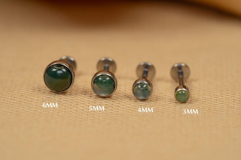 Puede incluir: Cuatro tachuelas de joyer&iacute;a corporal plateadas con piedras de &aacute;gata verde. Las piedras tienen un di&aacute;metro de 6 mm, 5 mm, 4 mm y 3 mm.