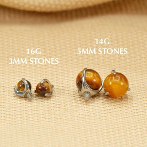 May include: Two pairs of tiger's eye gemstone earrings. The smaller pair is 16 gauge with 3mm stones. The larger pair is 14 gauge with 5mm stones.