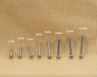 Puede incluir: Un conjunto de 8 varillas metálicas plateadas de diferentes longitudes, que van de 5 mm a 12 mm. Las varillas están dispuestas en orden de tamaño sobre un fondo de tela marrón.