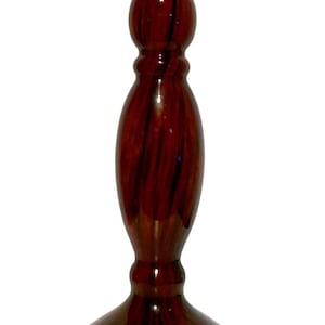 May include: A tall, decorative candlestick holder with a dark brown, swirling pattern. The candlestick has a wide, rounded base, a long, oval-shaped center, and a flared top. The overall design is elegant and suitable for various home decor styles.