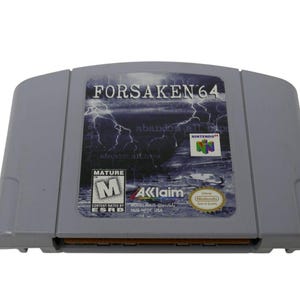May include: A gray Forsaken 64 Nintendo game cartridge. The label features the game title, a lightning graphic, and the Nintendo logo. The cartridge has a Mature rating from the ESRB and the Acclaim logo.