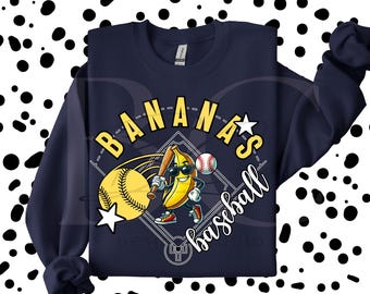 May include: Navy blue sweatshirt with a baseball-themed graphic. The design features a yellow banana wearing sunglasses and holding a baseball bat, with a baseball and the words "Bananas baseball". A fun, playful design.