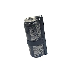Könnte beinhalten: Eine schwarze Dose Monster Energy-Getränk in einem schwarzen Halter. Die Dose wird von einem schwarzen Riemen und einer schwarzen Halterung gehalten. Die Dose hat weißen Text und der Halter hat einen Schlitz zur Montage.