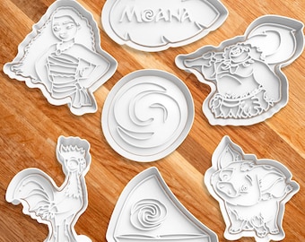 May include: Set of seven white plastic cookie cutters featuring characters and symbols from the Disney movie Moana. The cutters include Moana, Maui, Pua the pig, Hei Hei the rooster, the ocean, a leaf with the word "Moana" on it, and a boat.