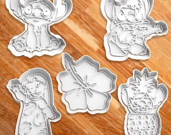 May include: Set of five white plastic cookie cutters featuring characters from the Disney movie Lilo & Stitch. The cutters include Stitch playing the ukulele, Stitch with a pineapple, Stitch with a flower, Lilo, and a hibiscus flower.