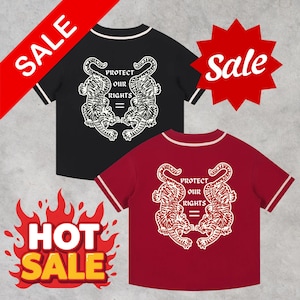 May include: Two baseball-style shirts, one black and one burgundy, with white trim on the sleeves and collar. Each shirt features a graphic of two tigers facing each other with the text "PROTECT OUR RIGHTS =" in white. "SALE" and "HOT SALE" graphics are also present.