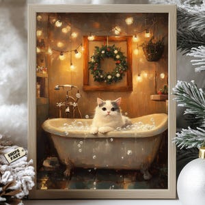 Könnte beinhalten: Ein gerahmter Druck zeigt eine flauschige, weiß-graue Katze, die sich in einer Vintage-Badewanne mit Blasen entspannt. Die Badezimmerszene umfasst einen Weihnachtskranz, Lichterketten und einen kleinen Hängekorb, wodurch eine gemütliche, festliche Atmosphäre entsteht.