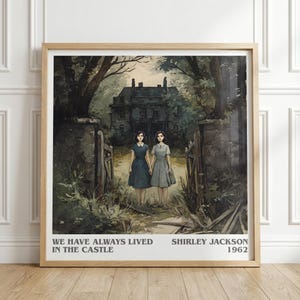 Puede incluir: Impresión artística enmarcada con una ilustración en acuarela de dos mujeres con vestidos frente a una mansión oscura. La impresión incluye el texto "WE HAVE ALWAYS LIVED IN THE CASTLE" y "SHIRLEY JACKSON 1962". La obra de arte está ambientada en una zona boscosa.