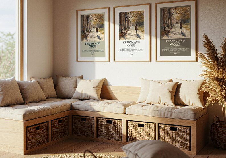 K&ouml;nnte beinhalten: Drei gerahmte Poster mit dem Text "Franny and Zooey" h&auml;ngen &uuml;ber einer eingebauten Bank mit beigen Kissen und Polstern. Die Bank hat gewebte Aufbewahrungsk&ouml;rbe. Ein gro&szlig;es Fenster und eine dekorative Pflanze sind ebenfalls sichtbar.