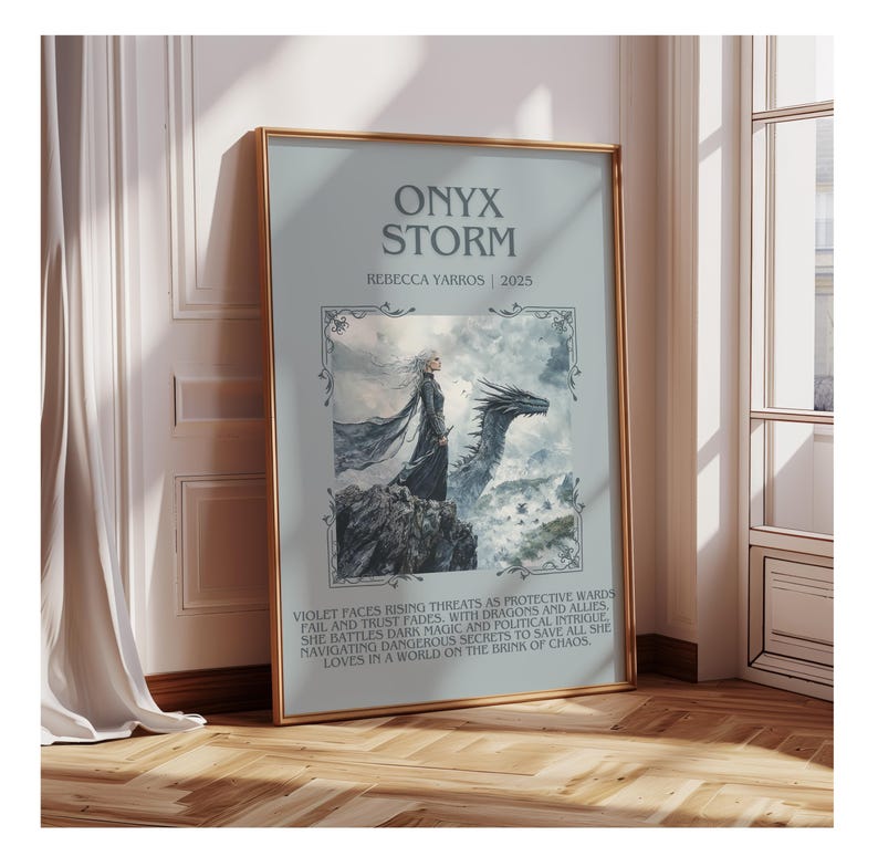 May include: Framed poster featuring the title "ONYX STORM" and author "REBECCA YARROS | 2025". The artwork depicts a woman and a dragon. The poster has a gold frame and is displayed against a light-colored wall.