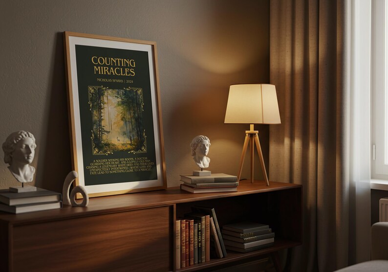 May include: A framed art print titled "Counting Miracles" with a forest scene. The print is displayed on a wooden cabinet, alongside a lamp, books, and a bust sculpture. The room has a warm, inviting atmosphere.