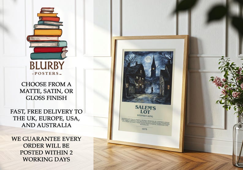 May include: A framed poster featuring a nighttime scene of a town with a church steeple under a full moon. The poster is titled "Salem's Lot" by Stephen King. The poster is in a wooden frame and is displayed on a wooden floor.