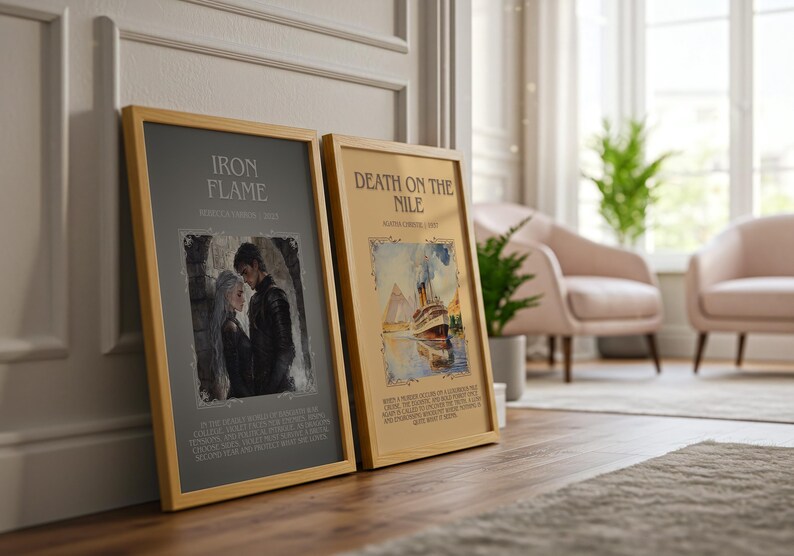 May include: Two framed art prints with wooden frames. The left print is titled "IRON FLAME" with an illustration of a couple. The right print is titled "DEATH ON THE NILE" with a watercolor painting of a ship. Both prints are leaning against a wall.