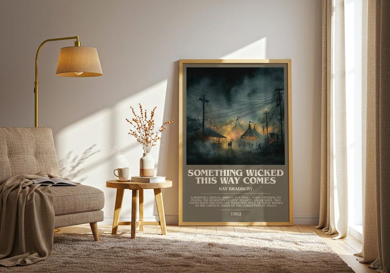 May include: Framed poster with the text "SOMETHING WICKED THIS WAY COMES" by Ray Bradbury. The artwork depicts a dark, atmospheric scene of a carnival with tents and figures, set against a stormy sky. The poster is displayed in a living room setting.