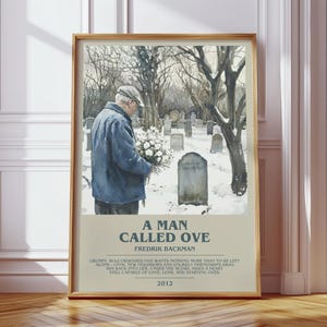 May include: A framed poster featuring a watercolor illustration of a person in a blue jacket and cap holding white flowers in a snowy cemetery. The text reads A MAN CALLED OVE, FREDRIK BACKMAN, and a summary of the book, with the year 2012 at the bottom.
