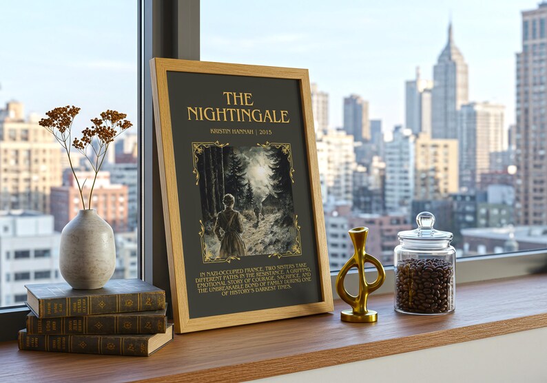 Peut inclure: Une impression encadr&eacute;e de "The Nightingale" de Kristin Hannah, expos&eacute;e sur une surface en bois avec des livres, un vase et un objet d&eacute;coratif dor&eacute;. Un bocal en verre rempli de grains de caf&eacute; est &agrave; proximit&eacute;, avec une vue sur la ville en arri&egrave;re-plan.