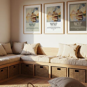 May include: Three framed posters of a vintage film advertisement, "Death on the Nile," hang above a built-in bench with beige cushions and pillows. Woven baskets are stored below the bench, and a tall plant is in a basket.