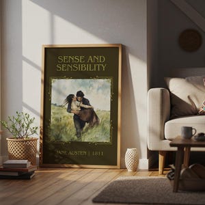 May include: A framed poster of "Sense and Sensibility" by Jane Austen, featuring a romantic watercolor illustration of a couple embracing in a field. The poster has a dark green background with gold lettering and a wooden frame, displayed in a living room.
