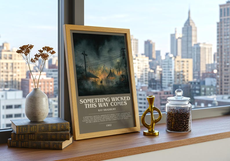May include: A framed print of "Something Wicked This Way Comes" by Ray Bradbury. The artwork depicts a carnival scene with a dark, ominous atmosphere. The print is displayed on a wooden surface with books, a vase, and a glass jar filled with coffee beans.