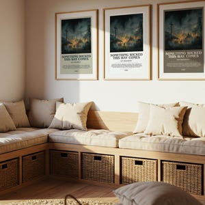 May include: Three framed posters with the text "SOMETHING WICKED THIS WAY COMES" hang above a built-in bench with beige cushions and pillows. The bench has woven storage baskets underneath. A large window and decorative plant are also visible.