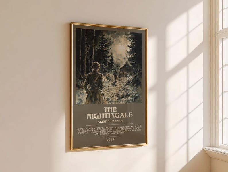 May include: A framed poster with a gold border, featuring a woman walking on a path through a forest. The poster's title is "The Nightingale" by Kristin Hannah, with text below describing the story and the year 2015.