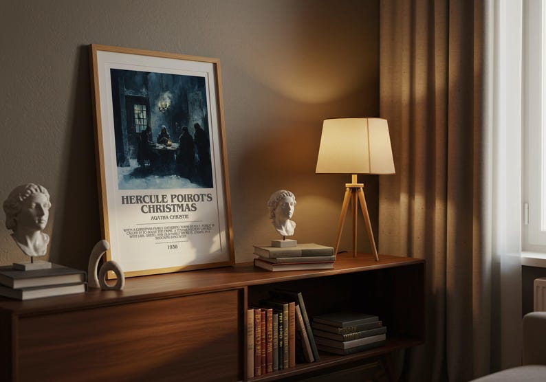 May include: A framed poster for "Hercule Poirot's Christmas" by Agatha Christie, displayed on a wooden cabinet. The scene includes a lamp, bust sculptures, and books. The poster is in a light wood frame.