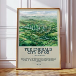 May include: A framed print of The Emerald City of Oz, featuring a vibrant green cityscape nestled in a valley. The artwork includes text at the bottom with the title, author, and a quote. The frame is a warm, natural wood tone.