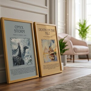 May include: Two framed art prints with wooden frames. The left print is titled "ONYX STORM" with a dragon illustration. The right print is titled "DEATH ON THE NILE" with a ship illustration. Both prints have decorative borders.