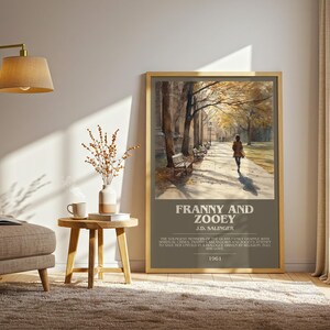 K&ouml;nnte beinhalten: Ein gerahmtes Poster mit dem Titel "Franny and Zooey" von J.D. Salinger. Das Kunstwerk zeigt eine Person, die auf einem von B&auml;umen ges&auml;umten Weg geht. Das Poster befindet sich in einem Raum mit einem Stuhl, einer Lampe und einem Beistelltisch.