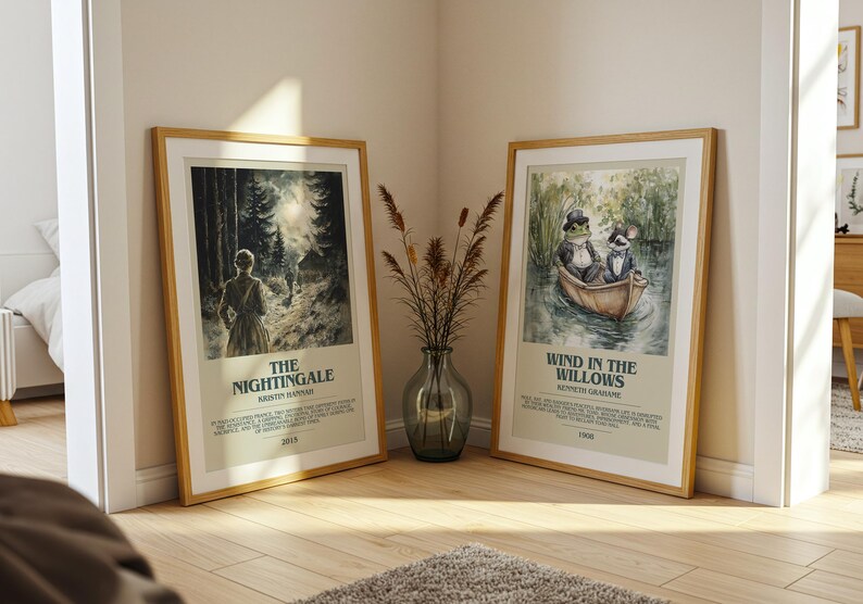 May include: Two framed art prints with wooden frames. One features a woman in a forest with the text "The Nightingale". The other depicts a frog and a rat in a boat with the text "Wind in the Willows". A vase of dried plants sits between them.